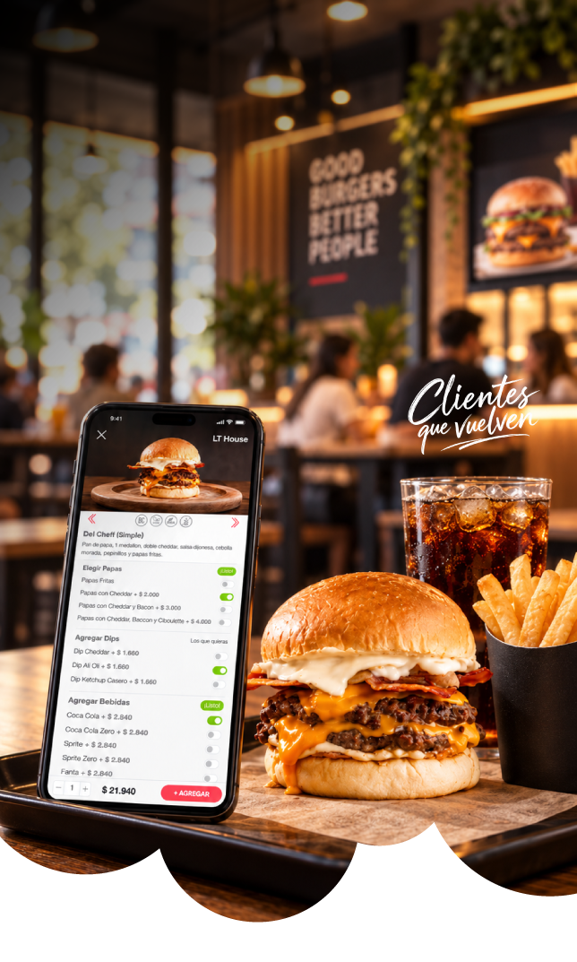 Pedido de hamburguesa en el celular junto a burger, papas y gaseosa en un mostrador.